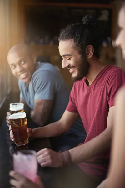 朋友们 男人们 带着啤酒在酒吧里欢度时光 在窗口观看放松或社交活动 在餐馆或俱乐部里 人们和饮酒的多样性 以及因结合和庆祝而带来的快乐 — 图库照片
