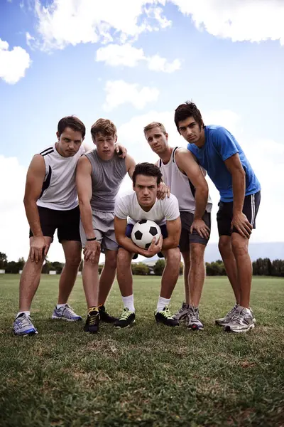 Soccer player, team and portrait in low angle, field and together with hug for training, exercise and workout. People, sports and football with scrum, embrace and solidarity for game in competition.