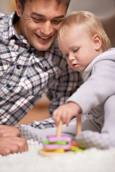Happy father, baby and playing with toys in house with love, pride and learning shapes or color in living room. Dad, daughter and educational game for creativity and development of fine motor skills.