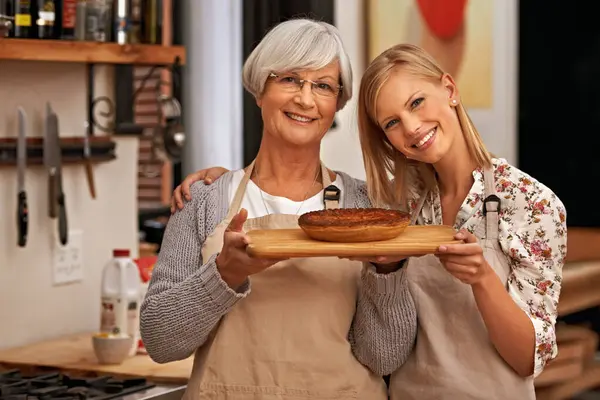 肖像画 快乐的女人和年长的母亲带着派在家里 做饭或微笑的家人一起在厨房里展示自制的食物 女儿和年迈的母亲 带甜点 糕点或帮助烘焙 — 图库照片