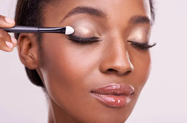 黒人女性 ブラシ メイク 美しさ ラッシュをピンクの背景に隔離したアイシャドウ スタジオで輝く化粧品 光沢のある光沢のある光沢 化粧品製品 ツール — ストック写真