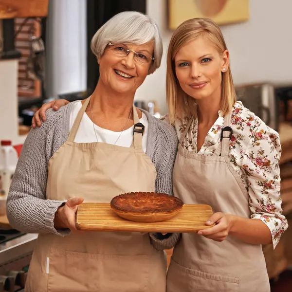 肖像画 快乐的女人和年长的母亲 带着派在厨房里 做饭或微笑的家人一起在家里展示自制的食物 女儿或年迈的母亲 带甜点 糕点或帮助烘焙 — 图库照片