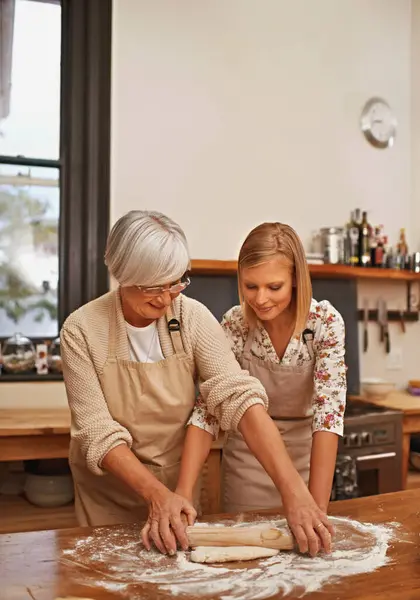 烘焙和奶奶在厨房与配料和年轻的女士一起教学和做饭 老年人或有围裙的老年人 在家里吃东西或吃甜点时微笑 — 图库照片