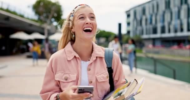 大学生の女性は キャンパスで勉強するためのミーム 本で歩いて電話で笑います 大学のソーシャルネットワーク上の面白い投稿のためのスマートフォンで少女 遺伝子 人と幸せ — ストック動画