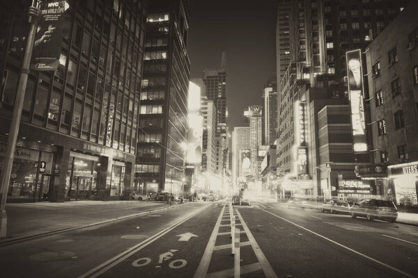 New York, city and downtown street or night adventure with buildings or black and white, dark or holiday. Road, urban and lights with cars or explore weekend or late outdoor vacation, evening or trip.