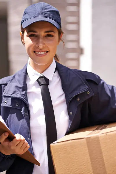 Delivery woman, box and outdoor in portrait by houses for distribution, smile or shipping job in neighborhood. Girl, courier and employee in supply chain, logistics or clipboard for cardboard package.