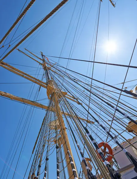 Sailing, ship and mast outdoor with rope for travel, journey and low angle of blue sky in summer. Boat, wood pole and vintage schooner vessel on a cruise, rigging and transportation with sunshine.