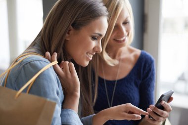 Kadınlar, akıllı telefon ve alışveriş çantası online alışveriş için oturma odasında, ekommerce ve evde kaynaşma için. Arkadaşlar, gülümseme ve teknolojiyle sosyal medya, anlaşma ya da indirimli ev haberleri.