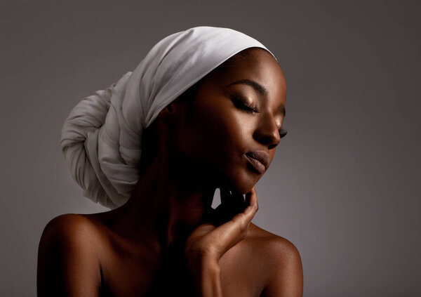 Beauty, cosmetics and black woman in dark studio with head scarf, skincare and pride in culture. Relax, skin glow and face of African model with dermatology, turban and girl on grey background.