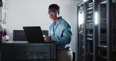 Bilgisayar, kodlama ve sunucu odasında yazılım, siber güvenlik veya programlama için insan mühendisliği. Profesyonel, bilgisayar ve Afrikalı erkek teknisyen ofiste teknolojiyle çevrimiçi veri tabanında çalışıyor.