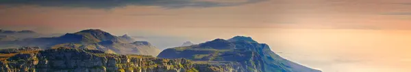 Mountain, landscape and banner of sky with clouds in heaven or countryside in Africa at sunset. Morning, outdoor and hill on horizon with aerial view of bush, nature or peak of environment with stone.