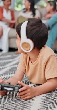 Çocuk, çocuk ve video oyunu oturma odasında, kulaklıklarıyla gülümseyerek, oynayarak ya da düşünerek. Çocuk, rahatla ve müzik dinlemek için oyun oyna ya da aile evinde esport için kontrol düğmesine tıkla.