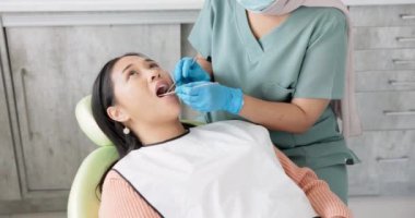 Kadın, dişçi ve hasta diş bakımında ağız temizleme, oral veya sakız gibi klinik aletlere sahip. Asyalı ya da kadın yüzü diş beyazlatma, hijyen ya da diş çürüğü temizleme için ortodontist ile rahatlar..