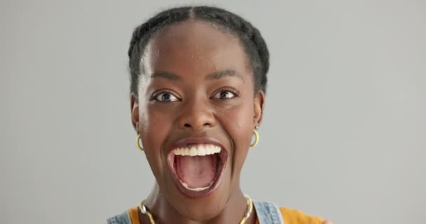 黒人女性 顔と成功や達成に興奮 取引やグレーの背景でのプレゼントのための競争で勝つ スタジオの肖像画におけるポジティブなサプライズ — ストック動画