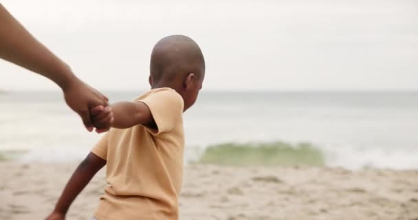 海の波によるサポート 結合および休日のためのビーチで手を握って下さい 家族とアフリカの子供は ゲームのヘルプとガイドで海や海岸に歩いています — ストック動画