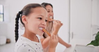 Anne, kız çocuğu ve banyoda diş fırçalama, taze nefes için sağlık ve diş, bağ ve sabah rutini. İnsanlar evde diş macunu ve diş fırçasıyla ağız temizliyor..