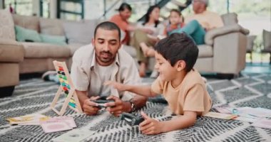 Baba, oğul ve video oyunu oturma odasının zemininde gülümseyerek, oynayarak ve aile evlerinde yarışmak için düğmeye basarak. Oyun, baba-oğul bağlılık, yarışma ya da esportla evdeki salonda halının üstünde.