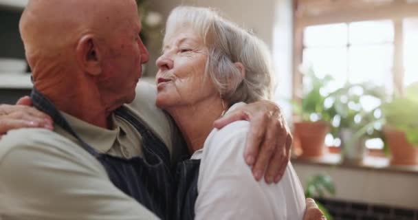 老年人 夫妻和亲吻在厨房与爱 支持和照顾在婚姻和退休 老年人 男人和女人都以善良或感激的心情拥抱着 因为他们在家里做饭时拥抱得很开心 — 图库视频影像