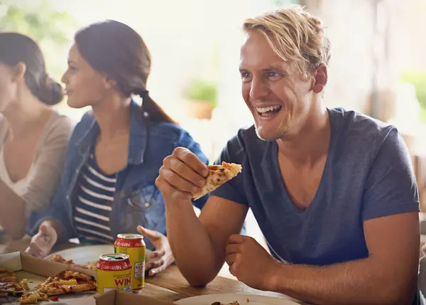 Friends, man and eating of pizza in home with laughing, soda and social gathering for bonding in dining room. Men, women and fast food with joke, funny and diversity at table in lounge of apartment.