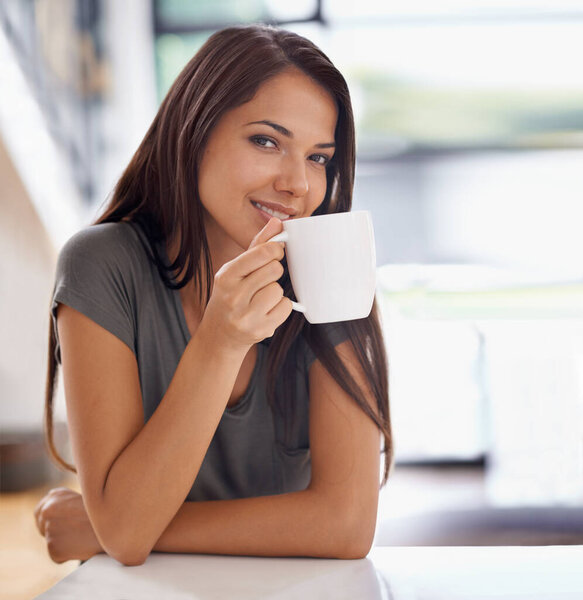 Portrait, coffee and happy with woman in kitchen of home to relax in morning or on weekend time off. Smile, relax and mug with face of young person drinking tea in apartment for peace or wellness.