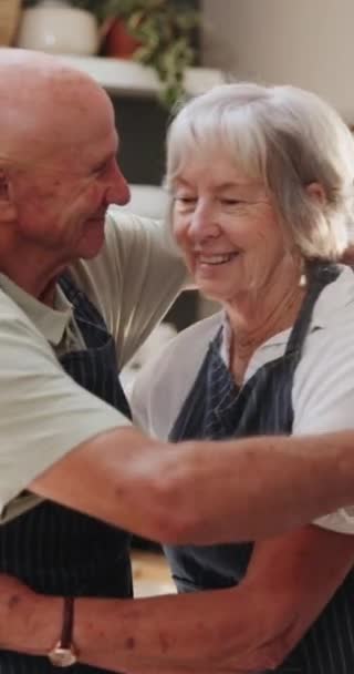 老年人 夫妻和拥抱在厨房与爱 支持和照顾在婚姻和退休 老年人 男人和女人都以善良或感激的心情拥抱在一起 因为他们在家里做饭时很快乐 — 图库视频影像