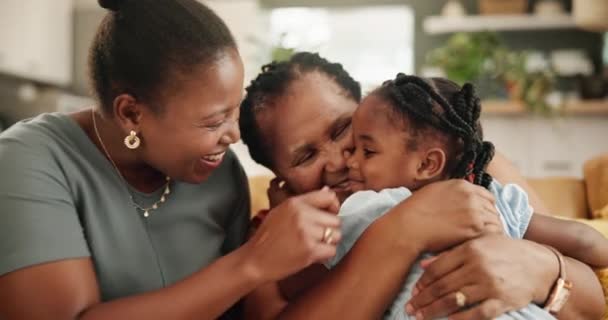 抱着孩子 与奶奶和妈妈在沙发上嬉笑 拥抱在一起 在家里客厅里 与母亲和老年妇女拥抱在一起 放松和年轻的女孩 — 图库视频影像