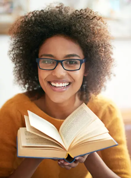 Book, portrait and black woman in living room to relax for literature, leisure and hobby at home. Smile, education and face of female student in lounge for learning, knowledge and information.
