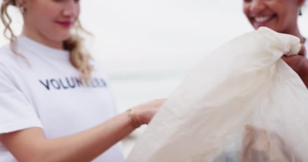チームワーク コミュニティサービス リサイクルバッグのためのハッピーな女性 ボランティア ビーチ ボランティア労働者は 海を救うためにゴミや汚れやゴミを触ったり収集したりします — ストック動画