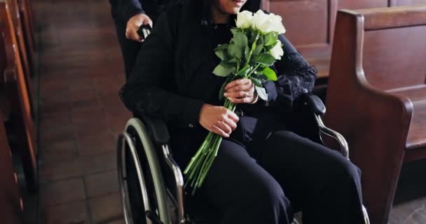 葬儀では 教会の葬儀で女性 車椅子 花がバラを手に入れています 悲しみや記念礼拝のためのチャペルの障害を持つ人を助けます 花束で死ぬか喪失 — ストック動画