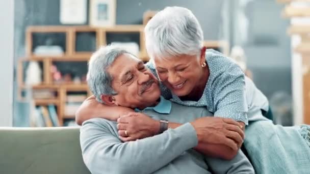 シニアカップル 抱擁し 愛と面白いメモリのための会話とソファーの世話 笑いと絆 高齢者女性 後ろから抱擁と幸せ 接続と自宅で覚えている — ストック動画