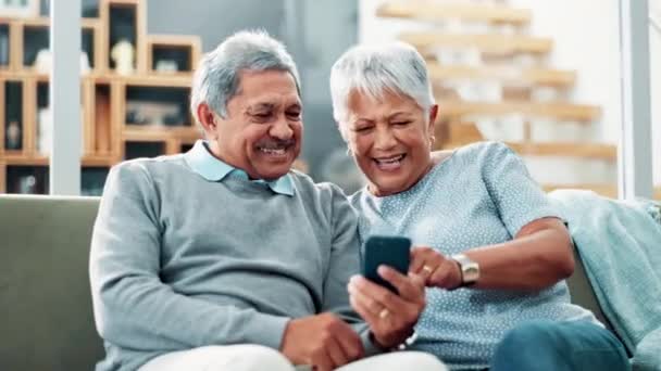 Ηλικιωμένο Ζευγάρι Χαρούμενος Και Τηλέφωνο Στον Καναπέ Ανάγνωση Για Αστεία — Αρχείο Βίντεο
