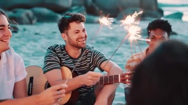 一緒に笑い ビーチでスパークラー 再会時に音楽と楽しいアウトドアのギター お祝い 自然の中で幸せな人 海の自由とパーティーのための社会集会 — ストック動画