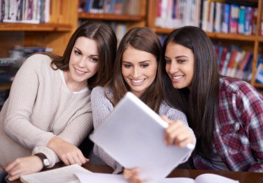 Üniversite kütüphanesinde kadınlar, öğrenciler ya da tablet selfie ya da arkadaş olarak destek için bir araya gelmek. Öğrenciler, dokunmatik ekran veya sosyal medyada profil resmi veya üniversitede özenle dayanışma.