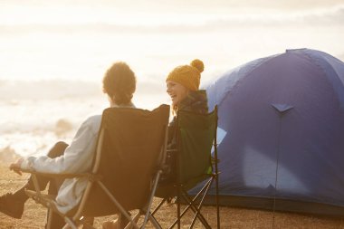 Mutlu, kamp yapan ve seyahat için çadır, macera ya da tatil yapan çiftler. Gülümse, aşk ve genç adam ve kadın konuşuyor, deniz kenarında haftasonu gezisi için dışarıda kaynaşıyor ve dinleniyor.