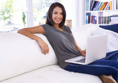 Portre, mutlu kadın ve dizüstü bilgisayar oturma odasında çalışıyor ya da kanepede gülümseyerek dinleniyor. Kadın kişi, izleme ya da yazma bilgisayar, teknoloji ve bağlantı sonuçları için lobide ya da evde.