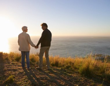 Mutlu tatiller ve doğada gün batımında el ele tutuşan çiftler Cape Town 'da tepede ya da dağda. İnsanlar, kırsal kesimde tatil maceralarında sevgi ve destekle birlikte rahatlayın..