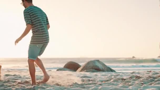 ハッピーな友人 ランニングや海でサッカーをすること 自然の中での冒険で一緒に結びつくこと サッカーの試合 ピクニック 海の砂での運動の多様性を持つ男性 — ストック動画