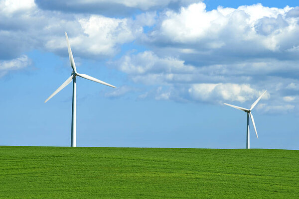Wind turbine, grass and sky with clouds for nature in environment and outdoor for landscape and energy. Sustainability, weather and season with ecology for farm and field in agriculture and industry.