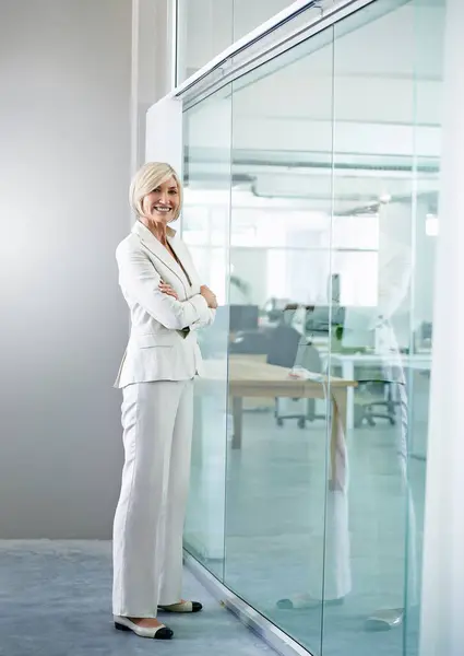 Business, office and woman with arms crossed at window in conference room with confidence or pride in London. Professional, entrepreneur and expert in strategy for corporate workshop or leadership.