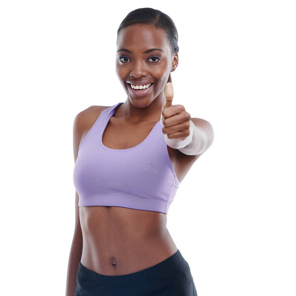 Portrait, fitness and thumbs up with happy black woman in studio isolated on white background for support. Exercise, like and yes with hand gesture of confident young sports model for motivation.
