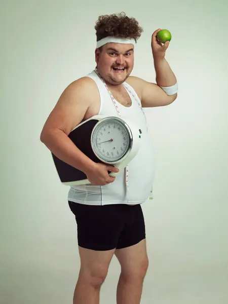 グレースタジオのバックグラウンドモックで隔離されたフィットネス 栄養のためのリンゴのスケール 幸せな男と肖像画 テープ測定付き男性の体重減少のためのプラスサイズ フルーツまたはダイエット — ストック写真