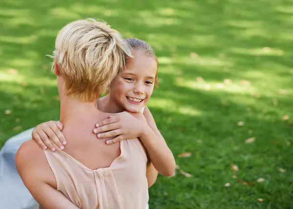 Mother, child and hug on garden grass for bonding connection in park for relax, parenting or summer. Woman, back and daughter embrace on home backyard for travel recreation or love, calm or happiness.
