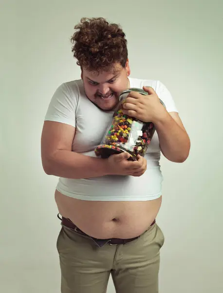 stock image Candy, jar and crazy plus size man in studio for snacks, sweets and dessert in container. Comic, funny and isolated silly person with glass for unhealthy diet, sugar and treats on white background.