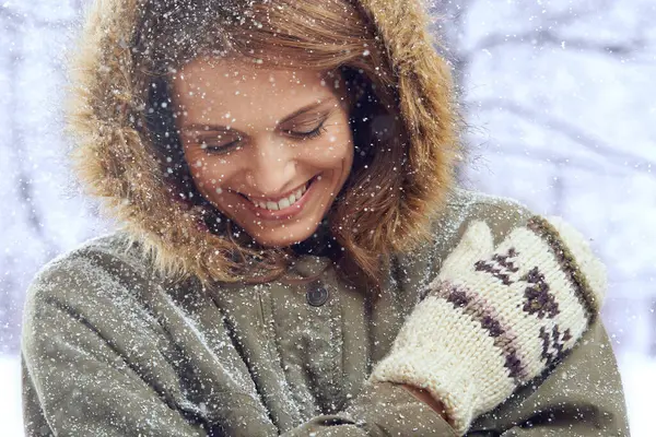 Happy, fashion and face of woman with snow outdoors for season, snowing weather and cold climate. Travel, forest and person smile in nature on winter holiday, vacation and weekend in Switzerland.