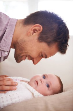 Baba, yeni doğmuş bebeği sevgi, destek ve bakım ile yatakta oynamak, babalık ve bağlılık. Heyecanlı baba, erkek ya da ebeveyn çocuğuyla birlikte evde gelişim, büyüme ve yetiştirme için heyecanlı.