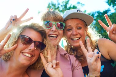 Barış, grup ve özçekim dışarıda tatil, fotoğrafçılık ve portre için kadınlar. Doğa, arkadaşlar ve yazın mavi gökyüzü, tatil ve kaçamakla mutlu ve bir gülümseme ve parmak hareketiyle heyecanlı.