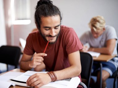 Üniversite öğrencisinde düşünmek, test etmek ve çözmek için kitap okumak. Fikirler, kalemler ve üniversite salonundaki gelişmeler için kişi, öğrenim ve değerlendirme.