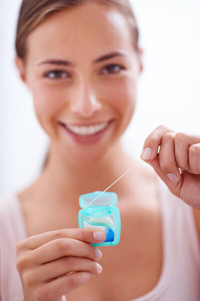 Portrait, smile and dental floss for oral hygiene care with woman in bathroom of home for teeth whitening. Face, product and happy young person in apartment to prevent tooth decay or gum disease.