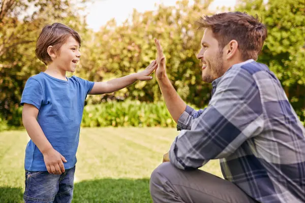 Çak bir beşlik, çocuk ve baba aile macerası, başarı ya da gelişim motivasyonu için parkta. Erkek, erkek çocuk ve heyecanlı el hareketleriyle mutlu. Destek, takım çalışması ya da doğada birlikte mutluluk..