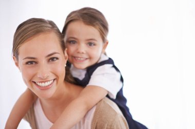 Anne, çocuk ve çocuk, beyaz arka planda oynarken, oyunlarla, sevgiyle ve gülümsemeyle portreyi bir arada taşıyorlar. Neşeli bir kadın, genç bir kız ve çocukluktan beri birlikte eğlenceli vakit geçirmekten mutlu..